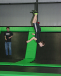 Boy Halfway through Flip on Trampoline at Indoor Fun Park